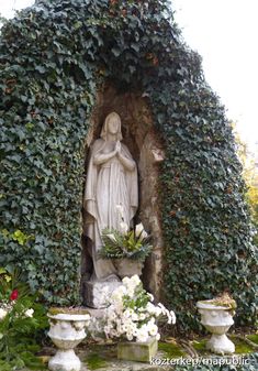 the statue is surrounded by ivy and flowers