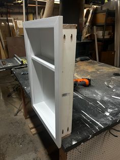 an unfinished cabinet is sitting on a workbench