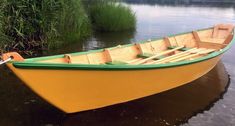 a yellow and green boat sitting in the water