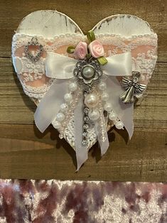 a heart shaped decoration with pearls and bows