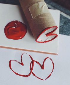 a rolled up piece of paper sitting on top of a sheet of paper next to a red wax stamp