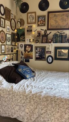 a bed sitting in a bedroom next to a bunch of pictures on the wall above it