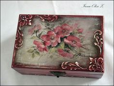 an ornate wooden box with pink flowers painted on it