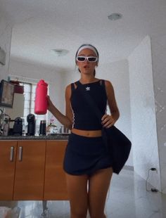 a woman wearing sunglasses is standing in the kitchen