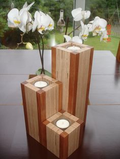 two wooden vases sitting on top of a table with white flowers in each one