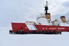 a group of people standing in front of a large red and white boat on snow covered ground