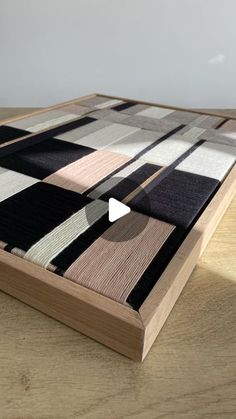 a wooden table topped with a black and white checkered pattern on top of it