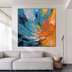 an abstract painting hangs on the wall above a white couch in a modern living room