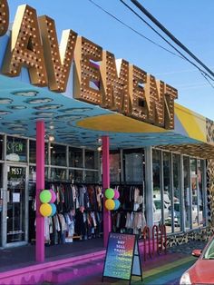 the front of a clothing store with neon lights on it's roof and windows