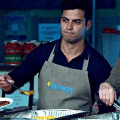 two men in aprons are preparing food together