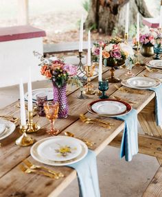 an outdoor table set with plates and place settings