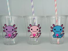 three plastic cups with different designs and colored straws