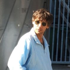 a man wearing sunglasses walking down the street