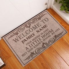 a welcome mat is on the floor in front of a door with a potted plant