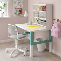 a child's desk and chair in a room with pink walls