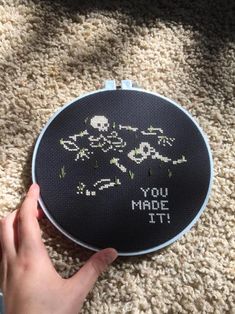 someone is holding up a cross - stitch project that says you made it on the floor