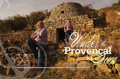 two men sitting on rocks in front of an old stone building with the words under the provencal sky