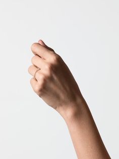 a person's hand holding something in the air with their right arm extended up