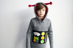 a young boy wearing a hoodie with an applique on it