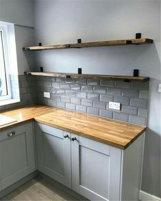 an empty kitchen with wooden counter tops and gray tile backsplashes on the wall