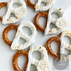 six pretzels decorated with white frosting and flowers