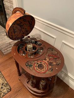 a wooden table with an open lid on top of it in front of a fireplace