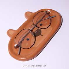 a pair of glasses sitting on top of a bear shaped object