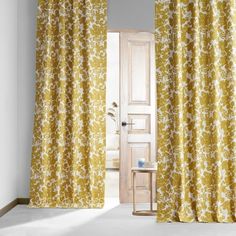 an open door with yellow curtains in front of it