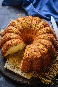 a bundt cake sitting on top of a wooden cutting board next to a knife