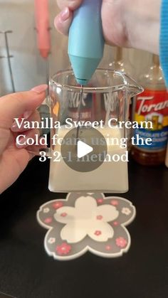 a person is using a small blender to make ice cream in a cup with the words vanilla sweet cream cold frosting on it