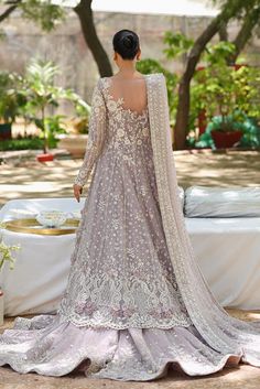 a woman in a wedding dress standing on the ground with her back to the camera