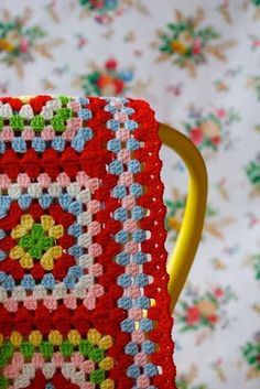 a crocheted granny square sitting on top of a yellow chair