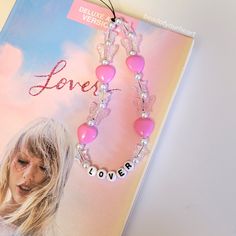 a pink beaded necklace with the word love on it and an image of a blonde woman's face