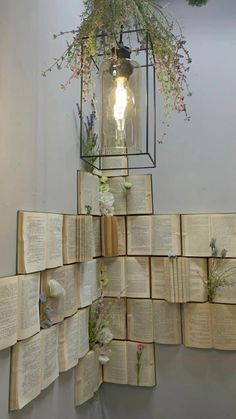 several open books are stacked on top of each other in front of a light fixture