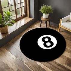 a black and white round rug with the number eight on it in front of a window