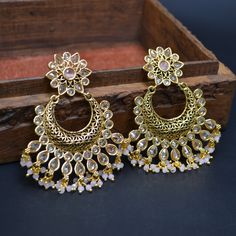 Elevate your elegance with our enchanting Baby Pink Indian Bollywood Earrings Set, a tribute to beauty and tradition. This exquisite ensemble, meticulously handcrafted, features delicate earrings that capture the essence of both Indian aesthetics and contemporary fashion. The soft baby pink hue radiates charm, making it a perfect choice for weddings, engagements, anniversaries, and celebratory gatherings. Each earring is a masterpiece, lovingly crafted from brass and adorned with intricate detai Gold Chandelier Earrings For Wedding And Festive Occasions, Festive Gold Chandelier Earrings For Wedding, Elegant Bridal Accessories With Intricate Design For Festive Occasions, Elegant Festive Bridal Accessories With Intricate Design, Elegant Earrings For Diwali Celebration, White Chandbalis With Intricate Design For Party, Elegant Wedding Chandelier Earrings With Stone Work, Elegant Gold Bridal Accessories For Festivals, Traditional Round Chandelier Earrings With Elegant Design