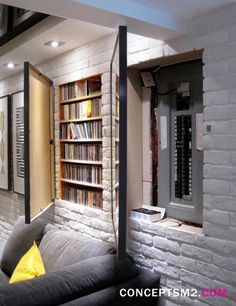 a living room filled with furniture and bookshelves next to a wall full of books