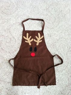 a brown apron with reindeer antlers on it's face is laying on the floor