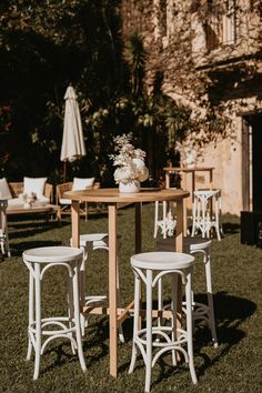 an outdoor table and chairs set up in the grass