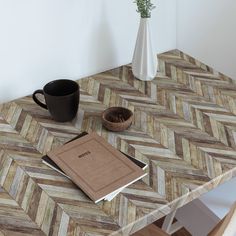 a table with a book, coffee cup and vase on it