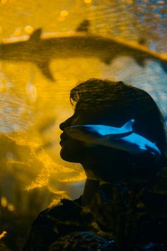 a woman is looking into the distance while wearing blue and yellow shades on her face