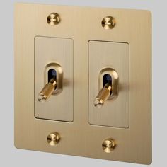 two light switch plates are shown with gold trimmings and one is turned on