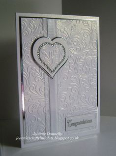 a white card with a heart on the front and side, in an ornate pattern