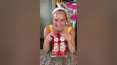 a woman holding up a can of soda