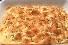 a square casserole in a white dish with green herbs on the top and sides