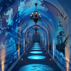 a tunnel with lights and paintings on the walls is lit up by chandeliers