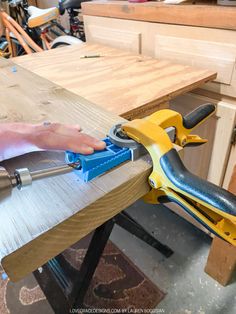 a person using a power tool on a piece of wood in a shop or workshop