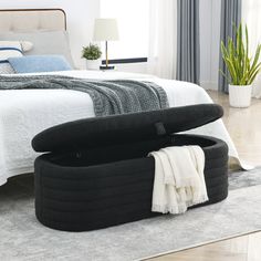 a bed with an ottoman underneath it in a bedroom