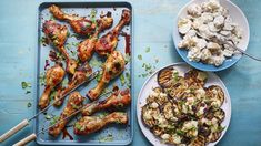 three plates with chicken, potatoes and other foods on them sitting on a blue table