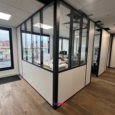 an office with glass walls and wooden floors